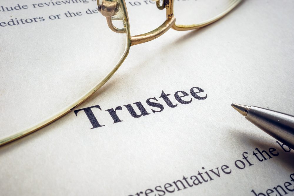 Word,Trustee,Near,Glasses,And,A,Pen.