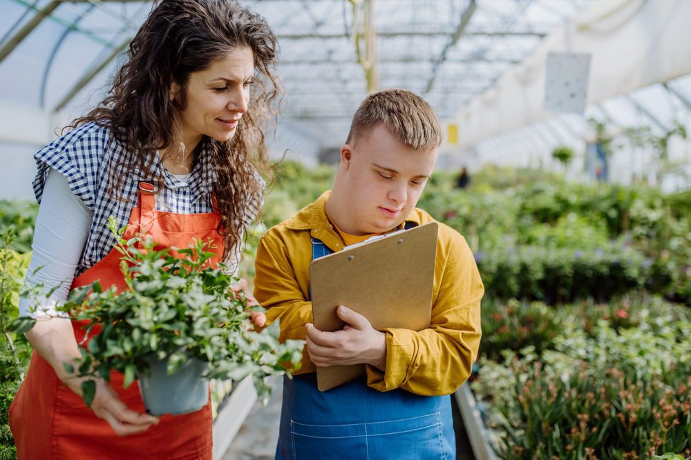 Experienced,Woman,Florist,Helping,Young,Employee,With,Down,Syndrome,To